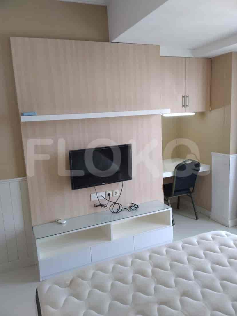 Bedroom with a TV, bed, and desk.