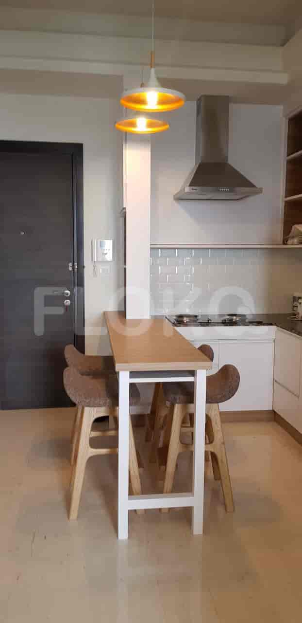 Modern kitchen with a breakfast bar, white cabinetry, and stainless steel appliances.