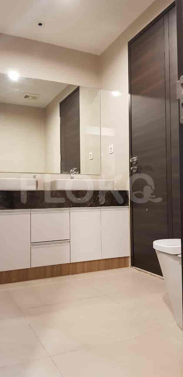 Modern bathroom with a large mirror, white vanity, and a toilet.