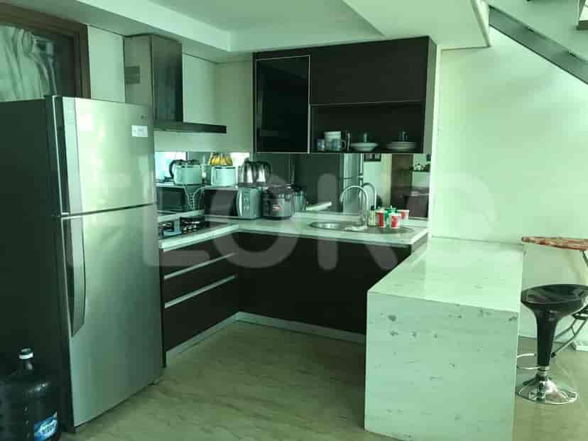 Dapur modern dengan kulkas, meja dengan wastafel, dan meja sarapan.