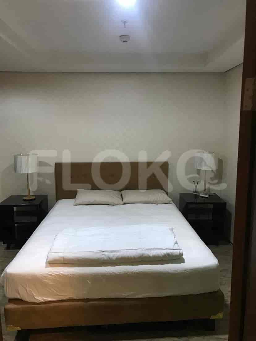 Kamar tidur dengan tempat tidur besar, dua meja samping tempat tidur, dan lampu.