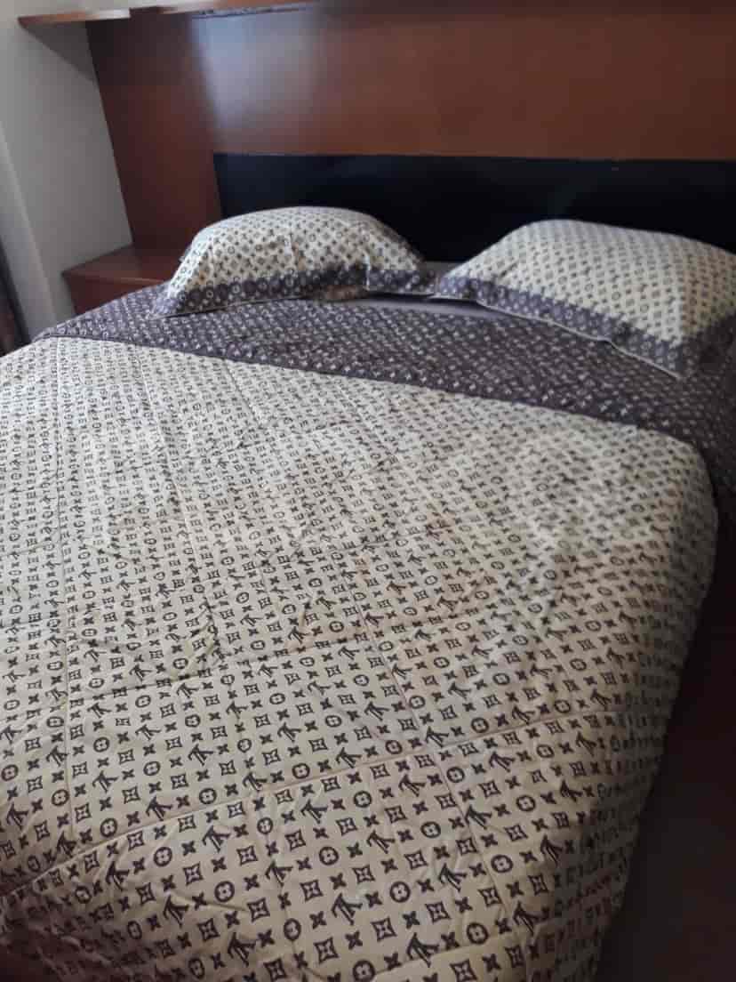 A close-up view of a bed with patterned bedding.