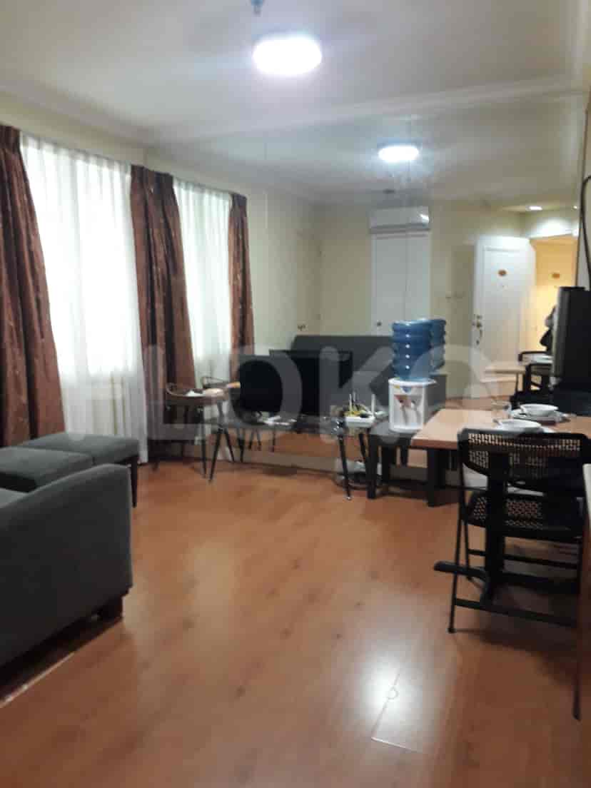 A living room with a sofa, table, and curtains.