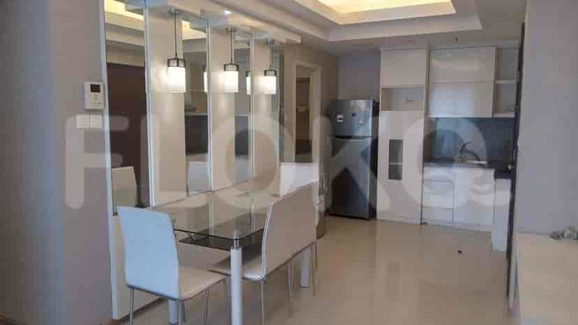 A combined living and dining area with a glass dining table and modern decor.