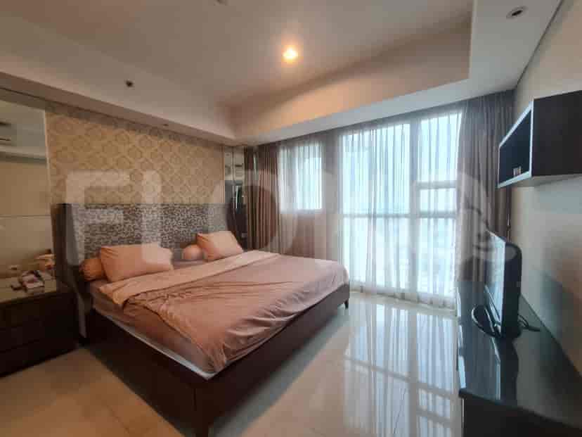 A luxurious master bedroom with a large bed and curtains.