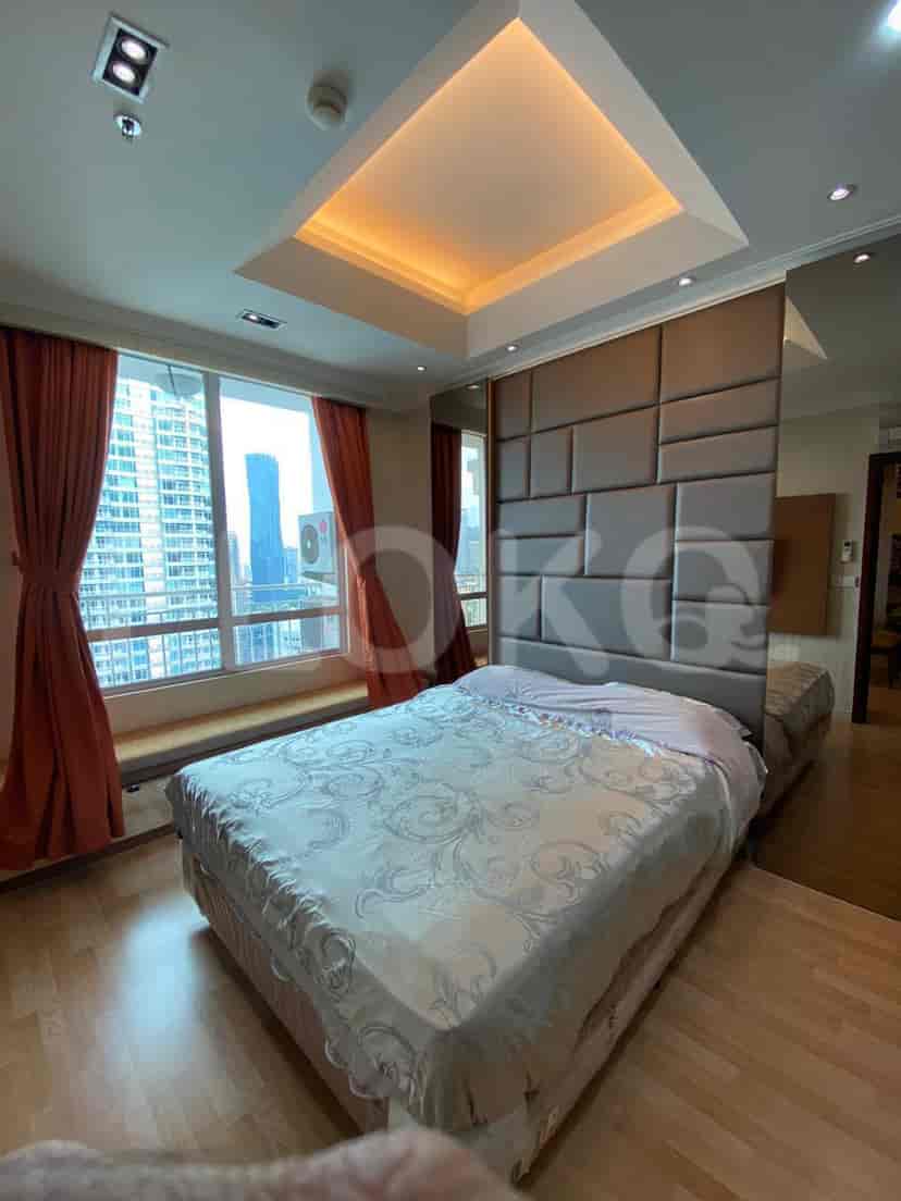 A modern bedroom with a king-size bed and large windows.