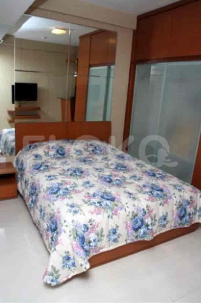 Bedroom with a bed, mirror wall, and a TV.