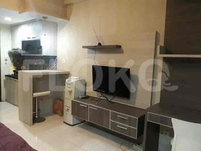 A living room area with a wall-mounted TV and a water dispenser.