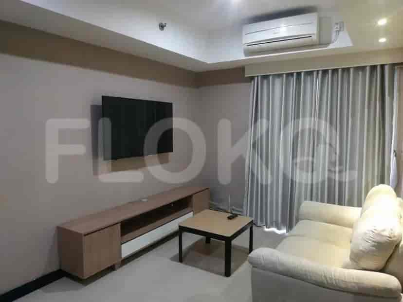 A living room with a sofa, smart TV, and table.