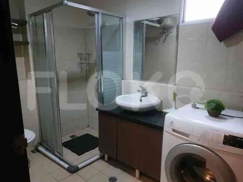 A bathroom with a shower, sink, and washing machine.