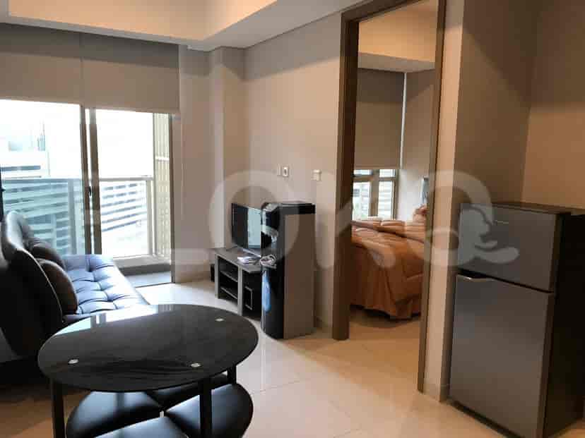 Living area with a view to a bedroom, including a sofa, tv, and water dispenser.