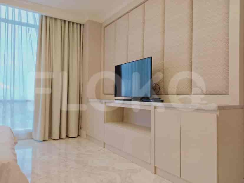 A bedroom with a TV mounted on a wall and a large window.