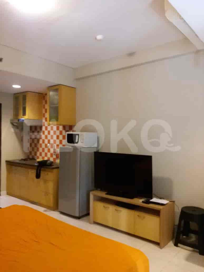 A studio apartment with a kitchen and a bedroom setup.