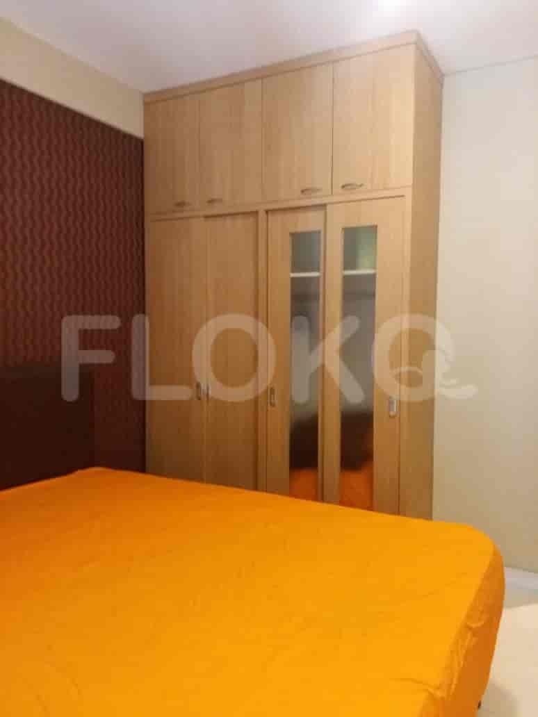 Bedroom with a bed and a wooden wardrobe.