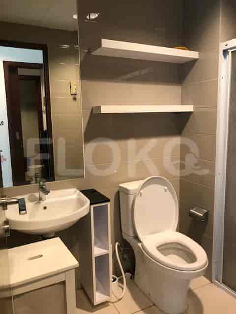 A modern bathroom with a toilet, sink, and shelves.