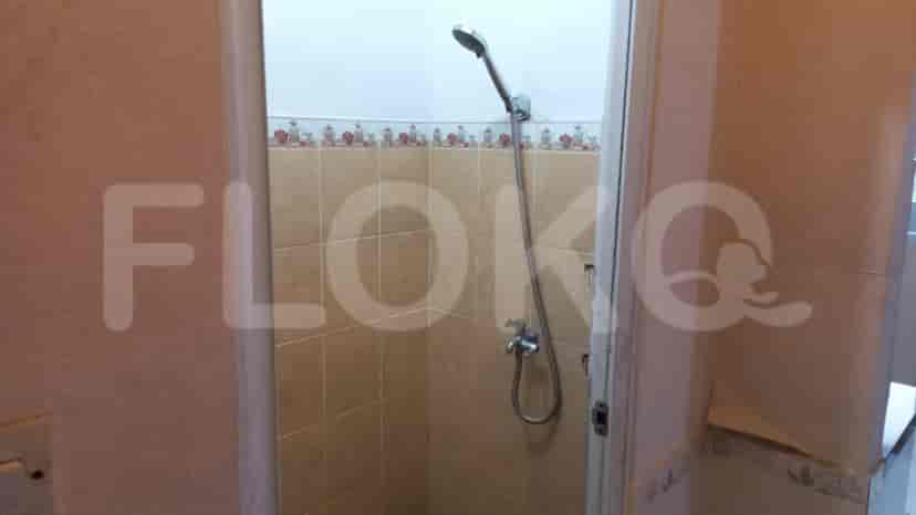 A small bathroom with a shower and beige tiles.