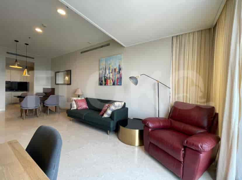 Living room and dining area combination, featuring a sofa, armchair, and a dining table.