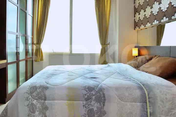 Bedroom with large windows, curtains, and a bed.