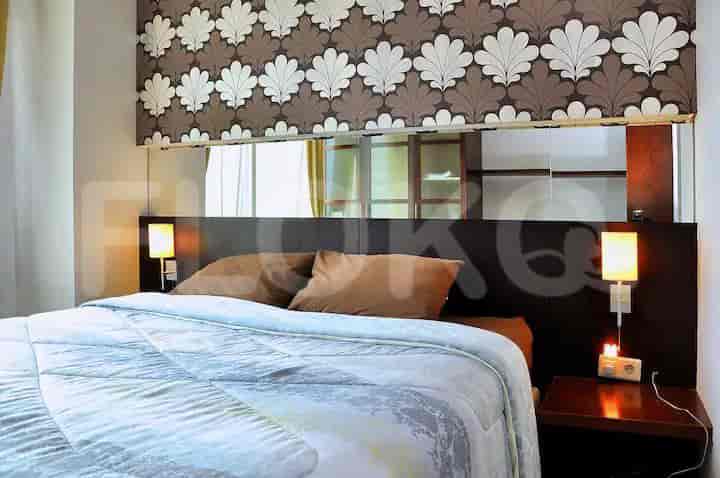 Bedroom featuring wallpaper, lamps, and a bed.