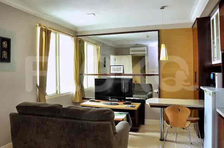 Another combined view of the living room and kitchenette with a TV and dining area.