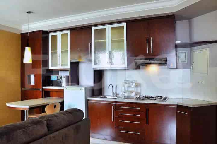 Another view of the kitchenette, featuring a stove, cabinets, and a dining area.