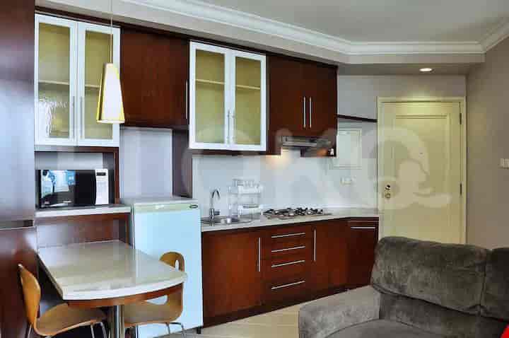 A compact, well-equipped kitchenette with cabinets, a stove, and a refrigerator.