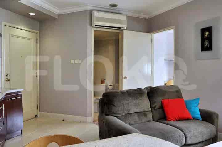 View of the living room including a sofa, access to the bathroom, and a dining area.