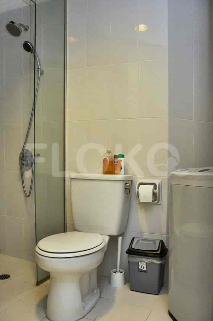 A modern bathroom with a shower, toilet, and laundry machine.