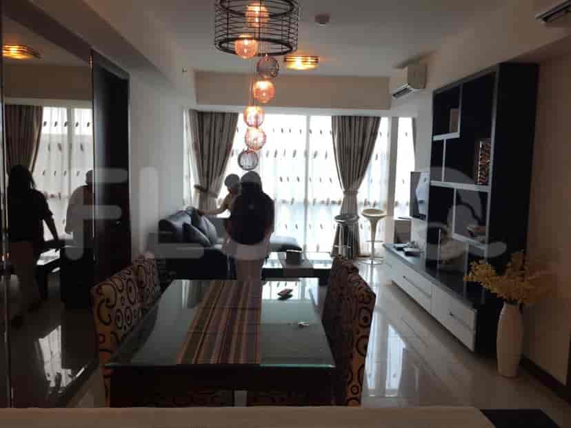 A well-lit living room with a dining area, a sofa, and an open kitchen.