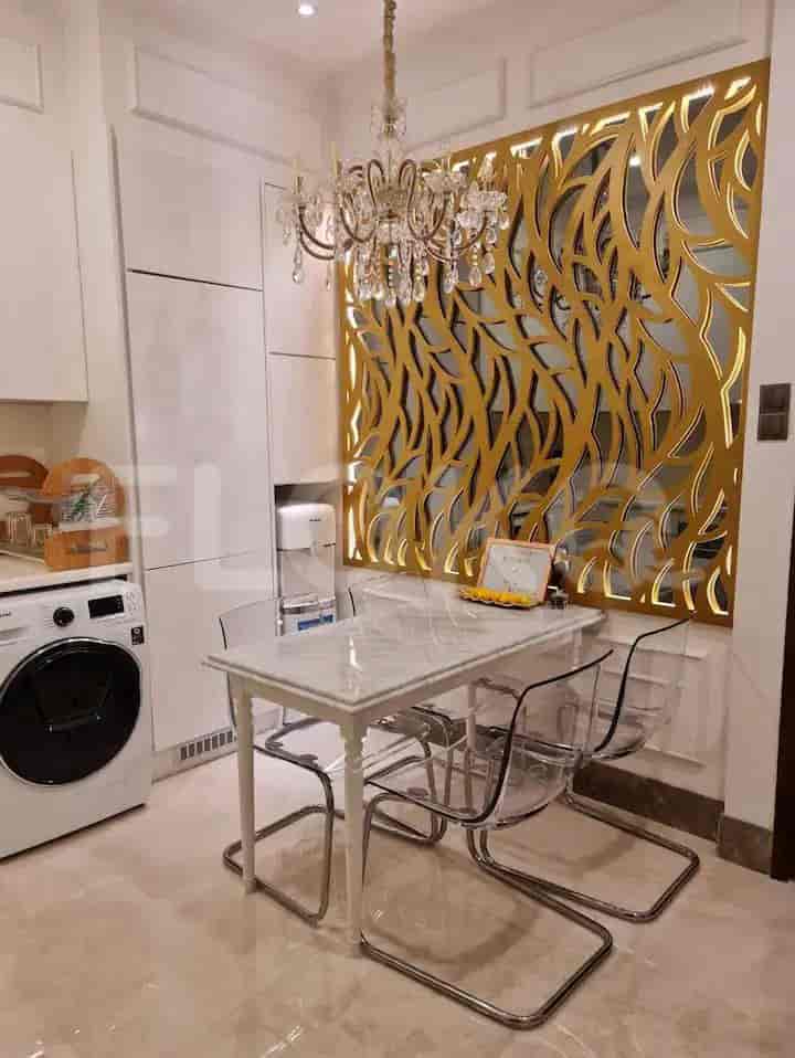 Modern kitchen with white cabinets, marble dining table, and crystal chandelier.