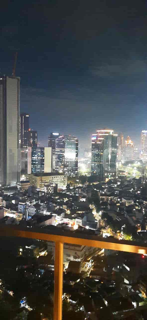A nighttime view of a city skyline from an apartment.