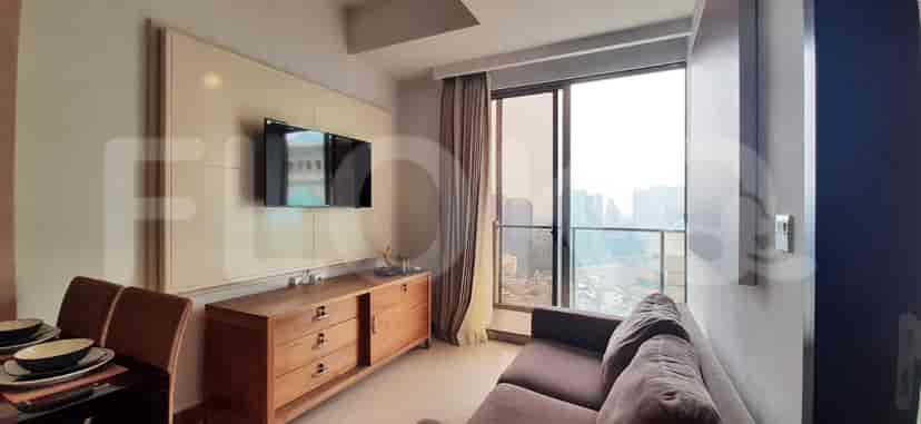 A living room with a TV, wooden cabinet, and large window.