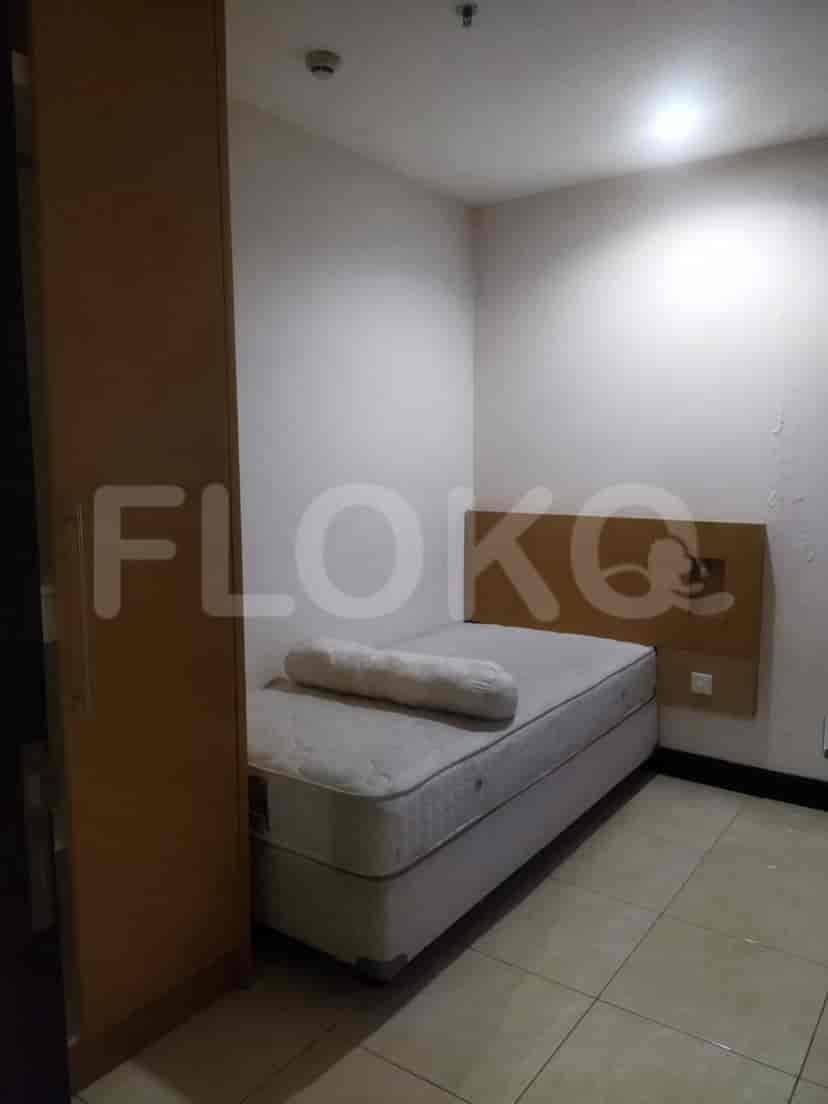 A compact bedroom furnished with a single bed and a closet.