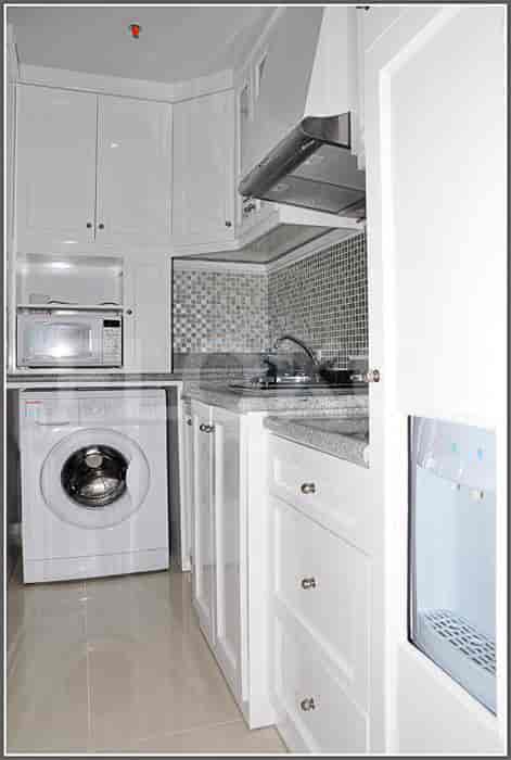 Well-equipped kitchen with a washing machine and a microwave.