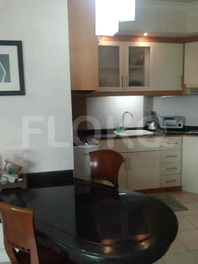 A kitchen and dining area with a wooden dining table and a view of the kitchen