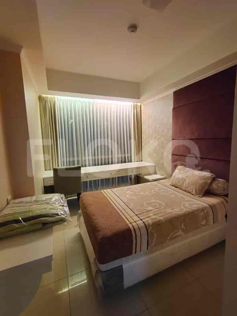 A bedroom with a bed, desk, and window.
