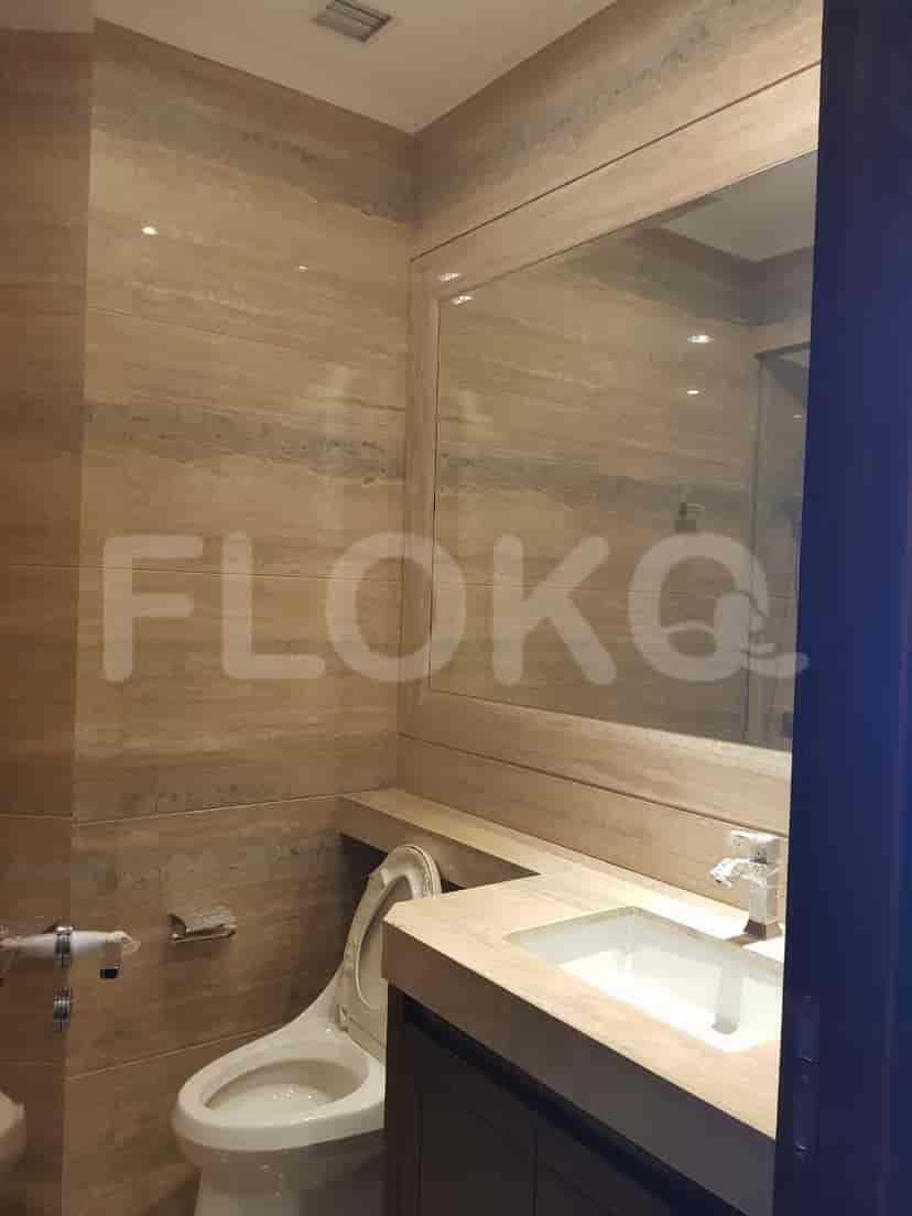 Bathroom with a toilet, sink, and large mirror.