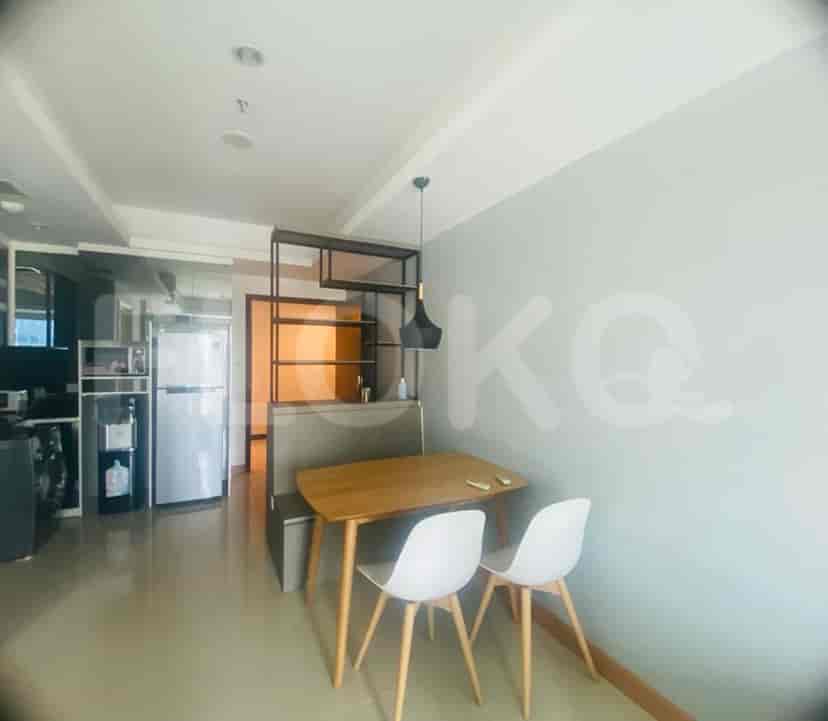 A dining area with a table, chairs, and kitchen behind.