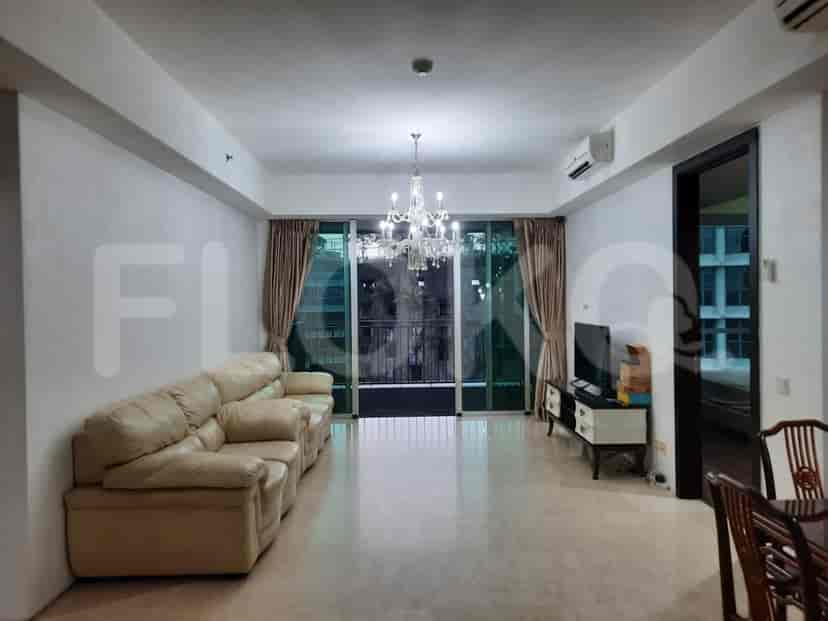 Spacious living room with a leather sofa, chandelier, and balcony access.