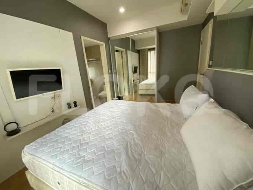Kamar tidur dengan tempat tidur, TV, dan cermin.