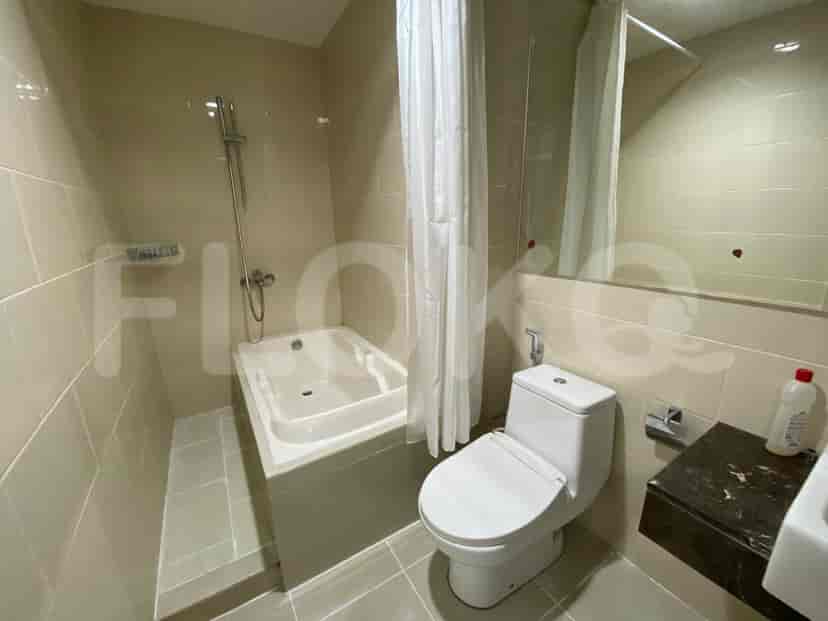 Kamar mandi dengan bak mandi dan dekorasi putih.