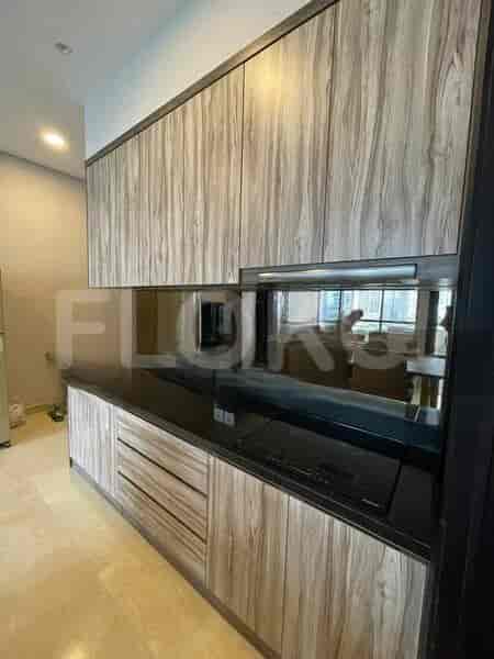 A modern kitchen with wooden cabinets, black countertops, and built-in appliances.