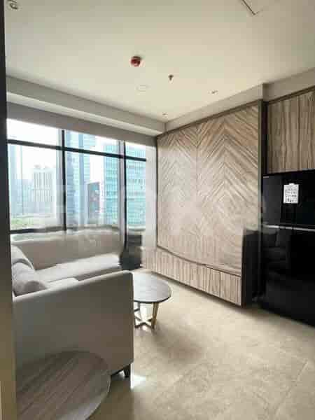 A modern living room with a beige sofa, round coffee table, and wooden accent wall.