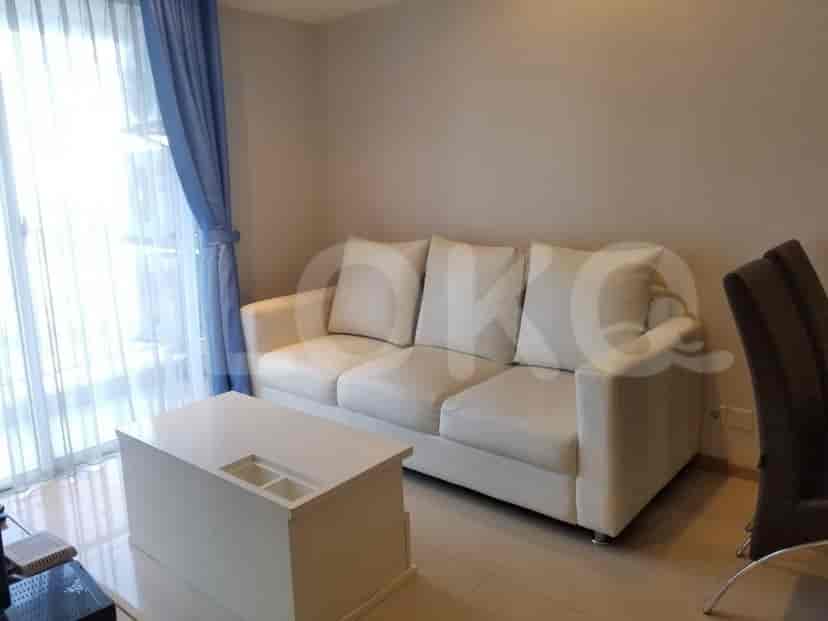 A spacious living room with a white sofa and a simple coffee table.