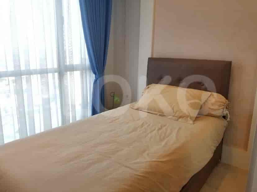 A cozy bedroom with a single bed, blue curtains, and a large window.