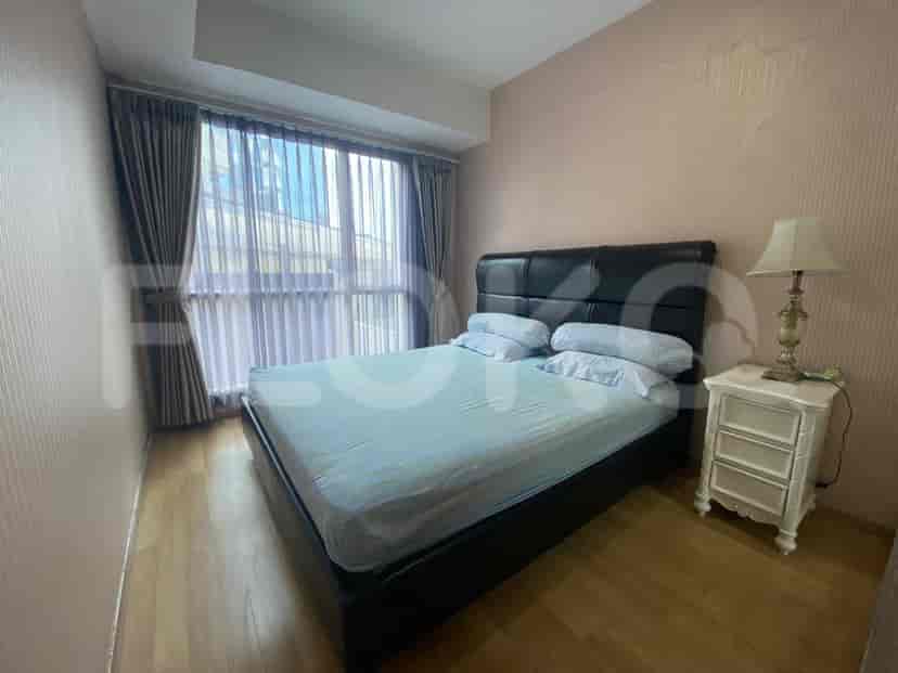 Cozy bedroom with a double bed, curtains, and a nightstand.