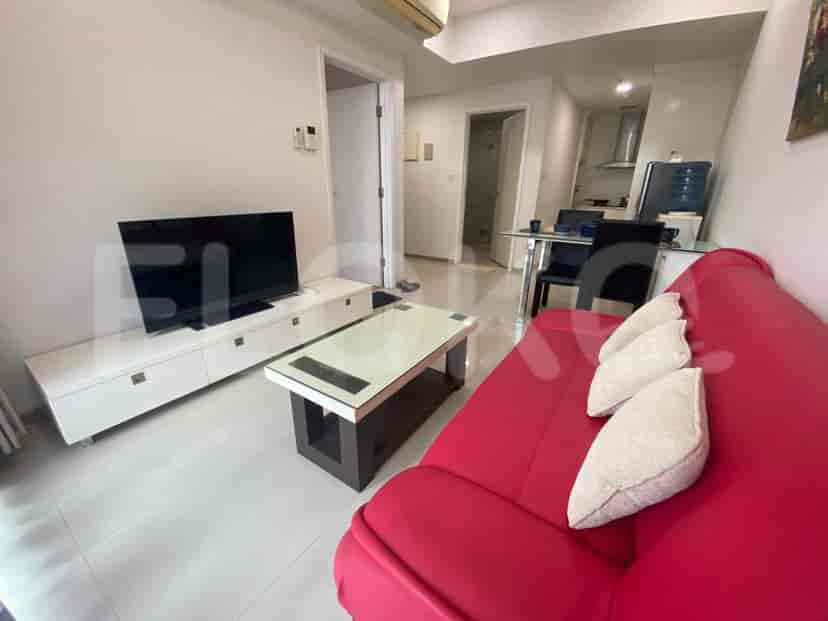 Modern living room with a red sofa, TV, and coffee table.