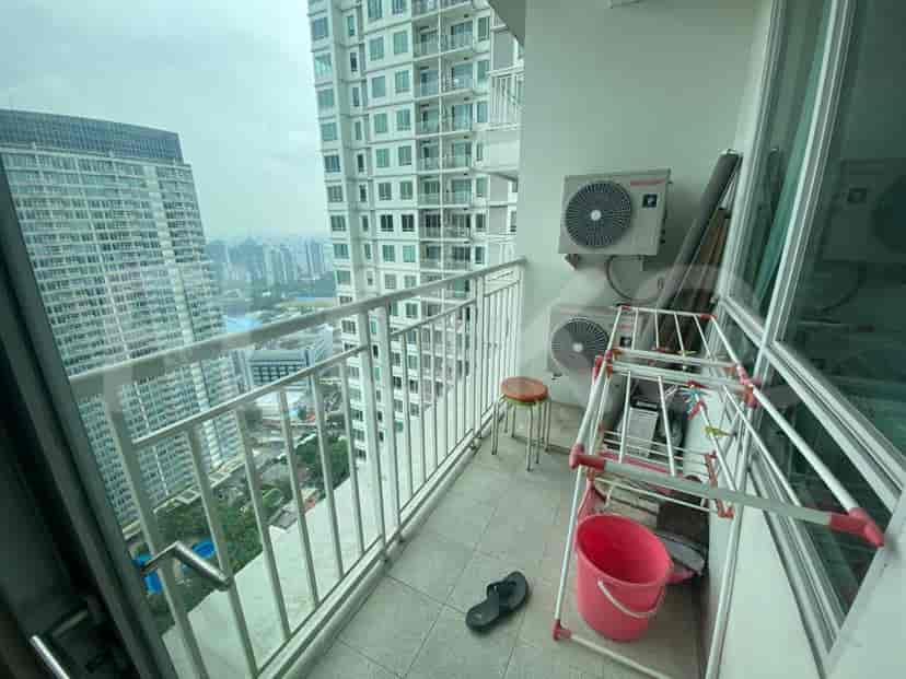 A balcony with a view of city buildings, air conditioning units, and a drying rack.