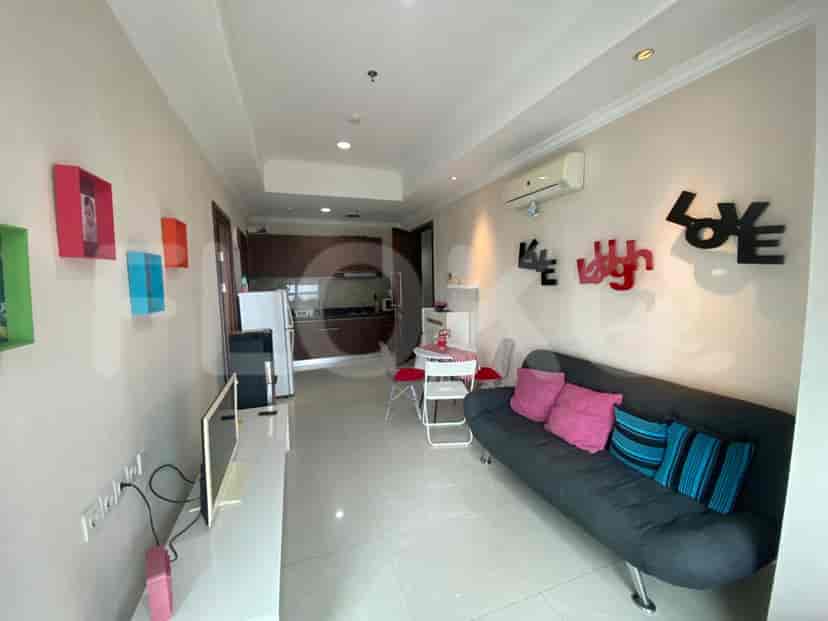Living room with sofa, wall art, TV, and a small dining area.