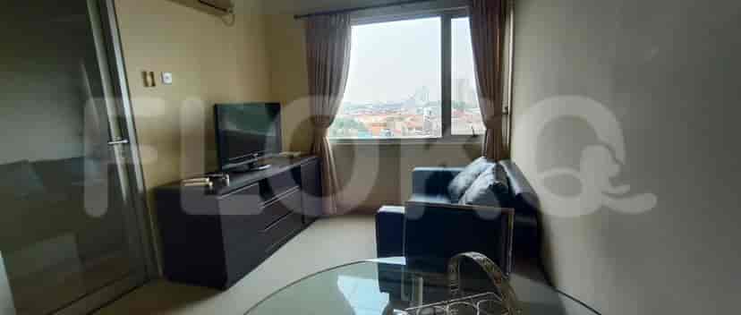 A living room with a TV, sofa, and dining area.